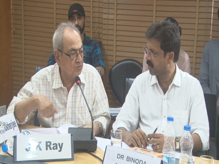 Prof J K Ray making a point at a CENERS-K seminar table, a colleague listening beside him and delegates seated behind.